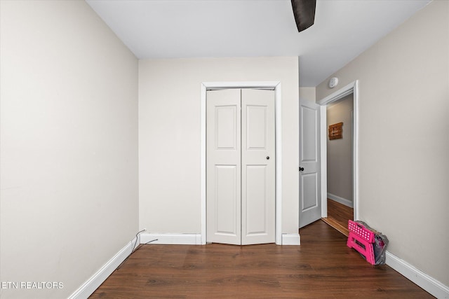 unfurnished bedroom with a closet, baseboards, and wood finished floors