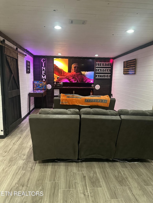 home theater with a barn door, visible vents, wood finished floors, and recessed lighting