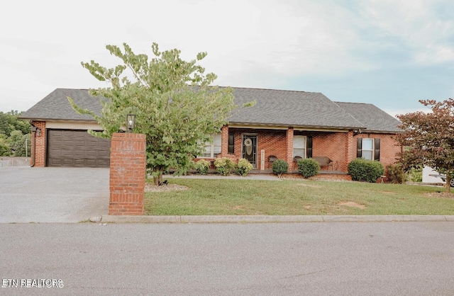 ranch-style home featuring concrete driveway, brick siding, a front lawn, and roof with shingles