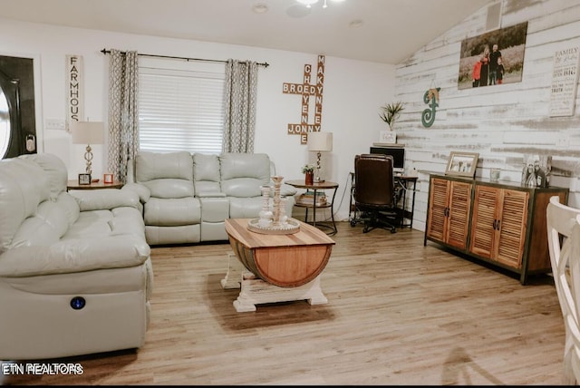 living area with vaulted ceiling and wood finished floors