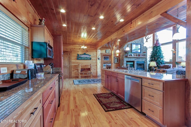 kitchen featuring light wood finished floors, wooden walls, wooden ceiling, stainless steel appliances, and a fireplace