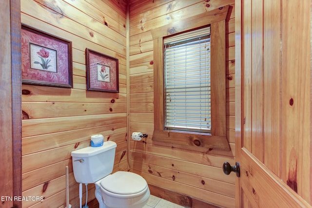 bathroom featuring toilet and wood walls