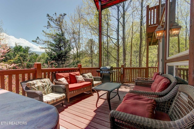 wooden deck featuring grilling area and an outdoor hangout area