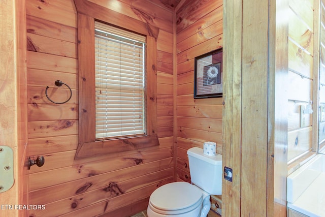 bathroom with wood walls and toilet