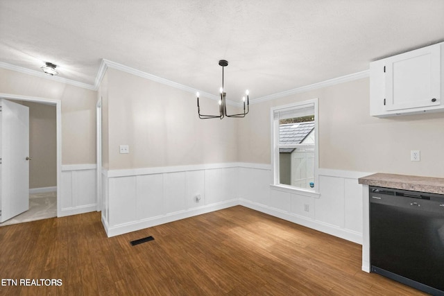 unfurnished dining area featuring a wainscoted wall, dark wood-style flooring, visible vents, and crown molding