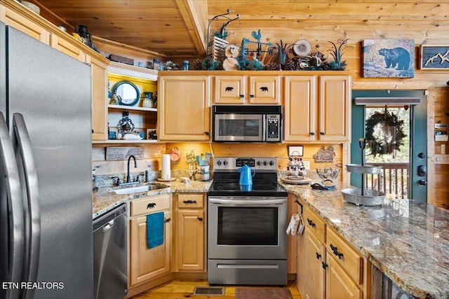 kitchen featuring wooden ceiling, appliances with stainless steel finishes, a peninsula, light stone countertops, and a sink