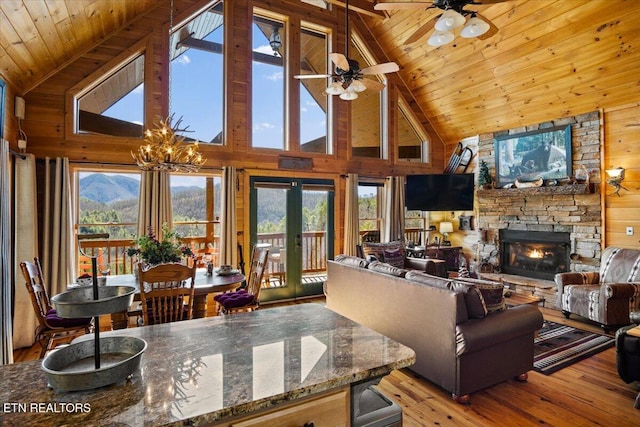 living room featuring vaulted ceiling with beams, a fireplace, wood ceiling, french doors, and hardwood / wood-style floors