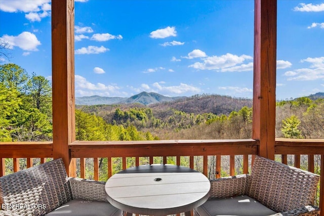 wooden deck with a mountain view and a wooded view