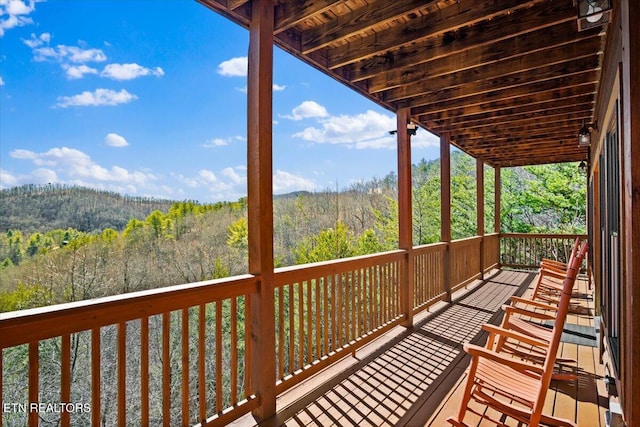 wooden terrace with a wooded view