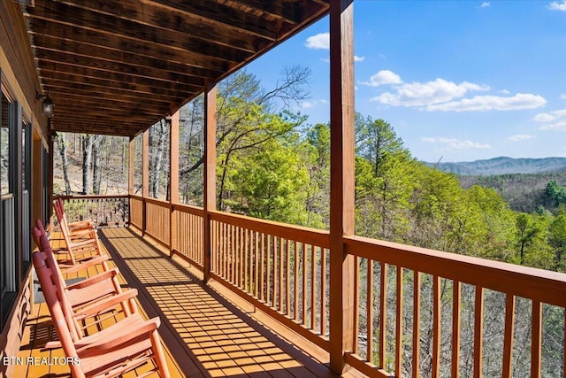 deck with a mountain view and a view of trees