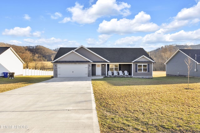 view of front of home featuring a porch, concrete driveway, an attached garage, fence, and a front lawn