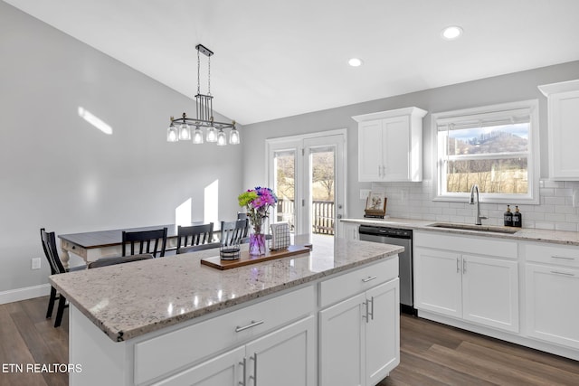 kitchen with tasteful backsplash, a center island, a sink, vaulted ceiling, and stainless steel dishwasher