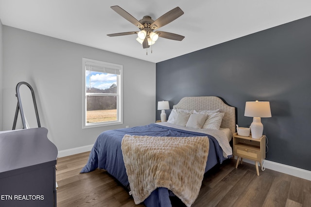 bedroom with a ceiling fan, baseboards, and wood finished floors