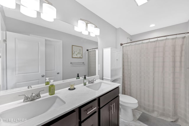 bathroom featuring a shower with shower curtain, a sink, toilet, and double vanity