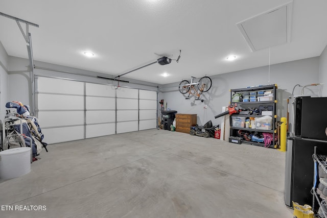 garage with freestanding refrigerator and a garage door opener