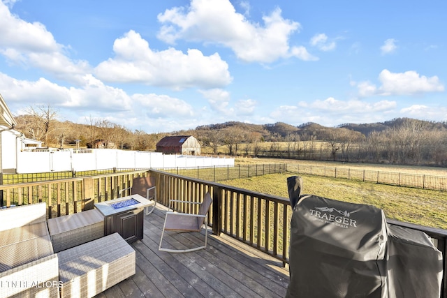 wooden terrace featuring an outdoor fire pit, a rural view, area for grilling, and fence