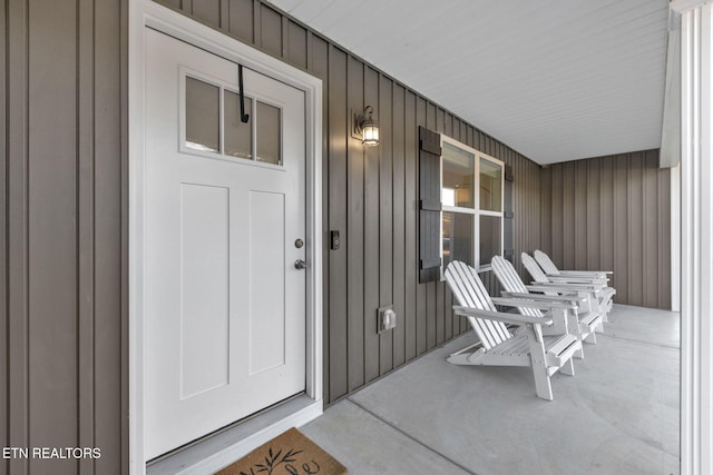 entrance to property with a porch and board and batten siding