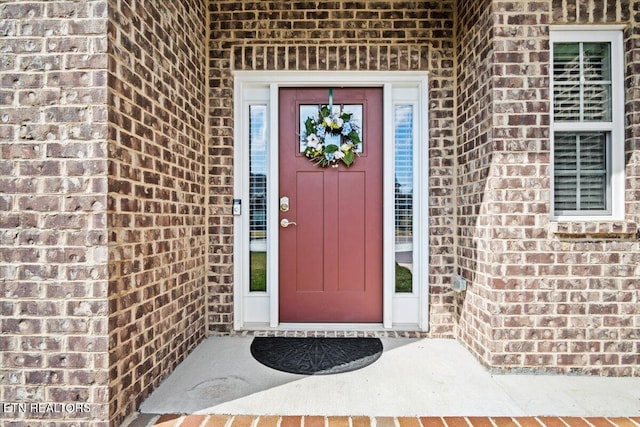 doorway to property with brick siding