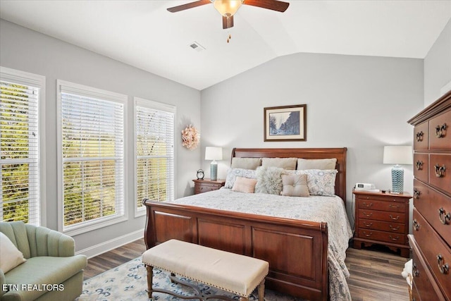 bedroom with lofted ceiling, ceiling fan, visible vents, baseboards, and dark wood finished floors