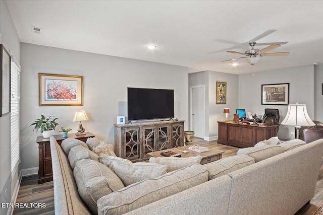 living room featuring visible vents, ceiling fan, baseboards, and wood finished floors