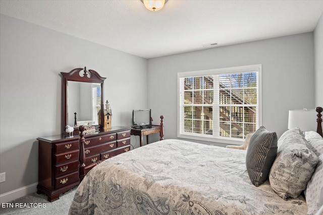 carpeted bedroom with visible vents and baseboards