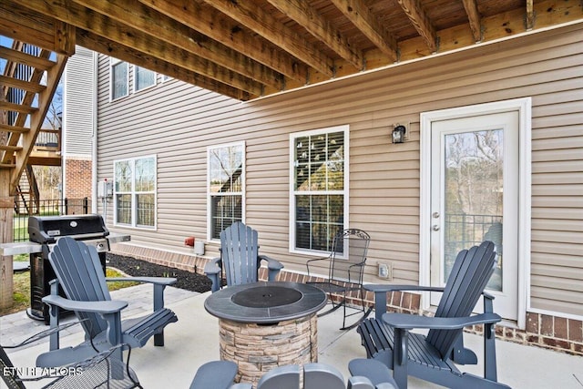 view of patio featuring a grill, fence, and a fire pit