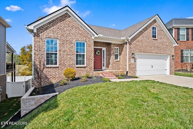 view of front of home with concrete driveway, brick siding, a front yard, and fence