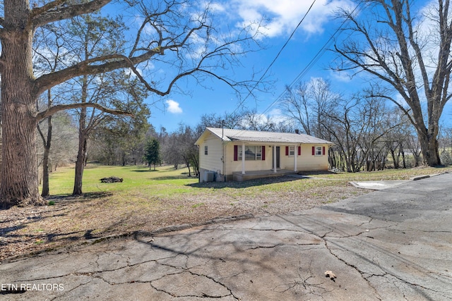 view of front of home with metal roof and a front yard