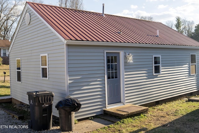 rear view of house featuring entry steps and metal roof