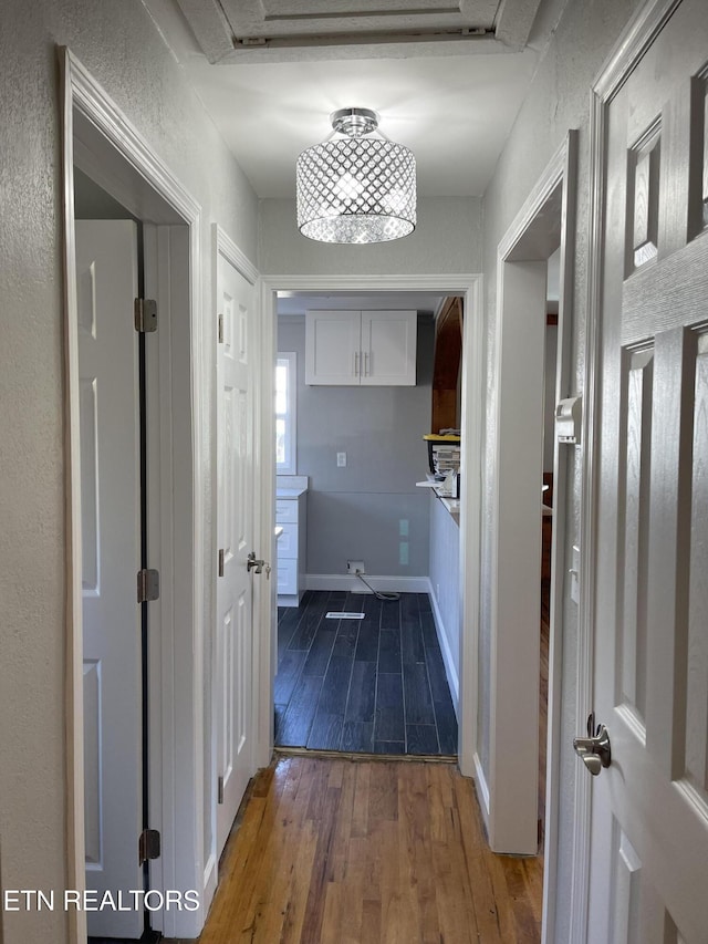 hallway featuring wood-type flooring and a textured wall