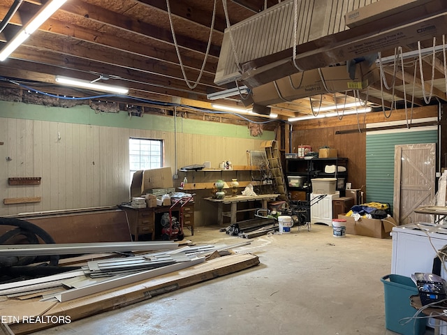 garage with wooden walls and a workshop area