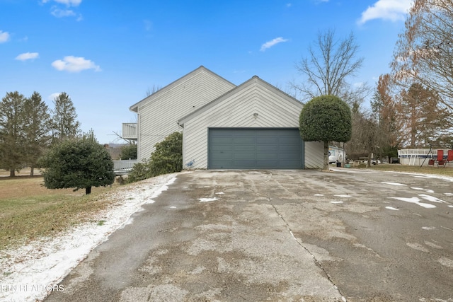 view of side of home with concrete driveway and an attached garage