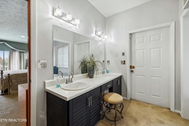 ensuite bathroom featuring double vanity, ensuite bath, and a sink