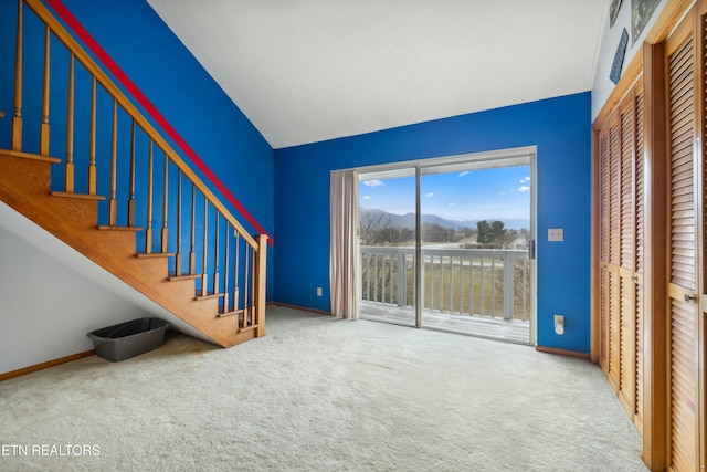 interior space featuring baseboards, stairs, a mountain view, and carpet flooring