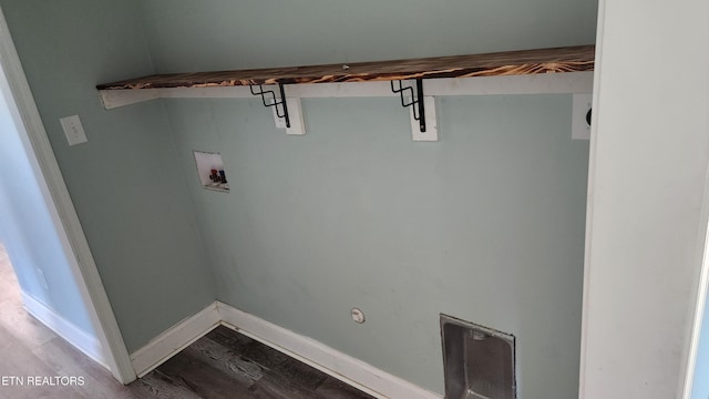 clothes washing area featuring laundry area, washer hookup, wood finished floors, and baseboards