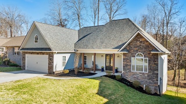 view of front of house featuring a garage, a front yard, driveway, and a shingled roof