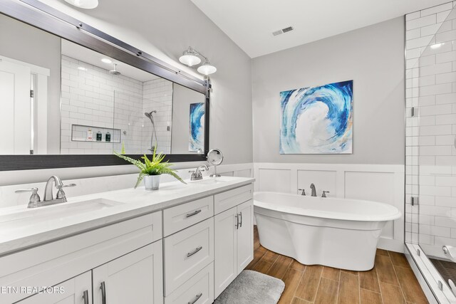 full bathroom featuring a stall shower, visible vents, a sink, and wainscoting