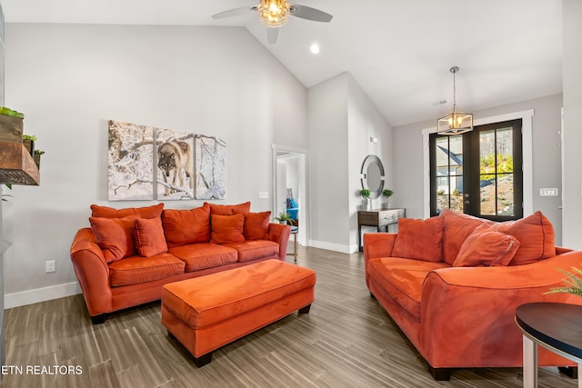 living room with high vaulted ceiling, a ceiling fan, baseboards, and wood finished floors