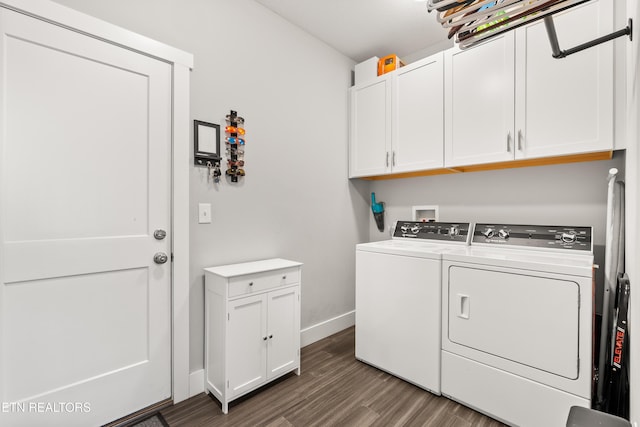 washroom with cabinet space, baseboards, dark wood-style flooring, and washer and dryer