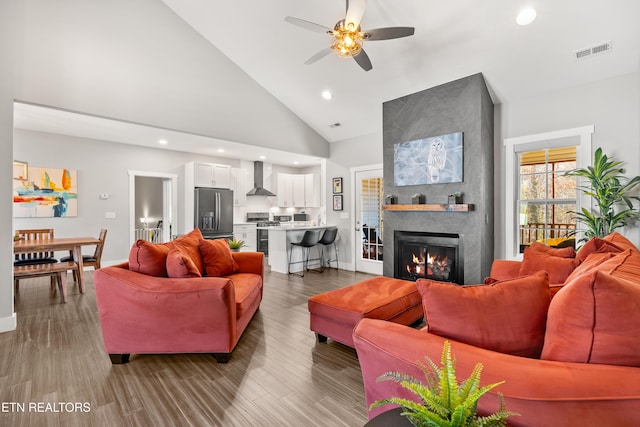 living area with recessed lighting, visible vents, a fireplace, and wood finished floors