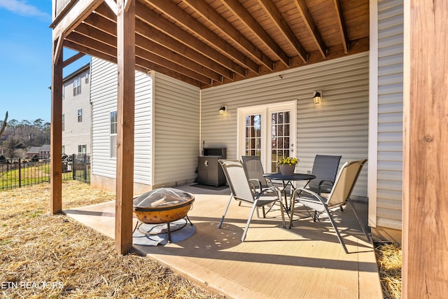 view of patio / terrace featuring fence, a fire pit, and outdoor dining area