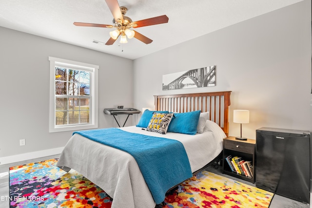 bedroom featuring visible vents, fridge, a ceiling fan, and baseboards