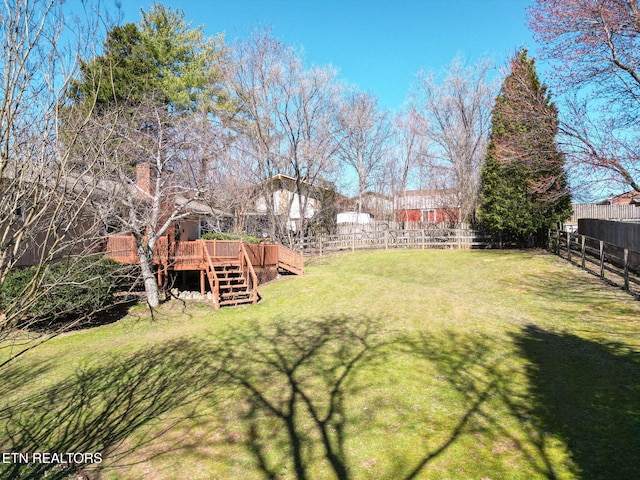 view of yard with stairway, a fenced backyard, and a deck