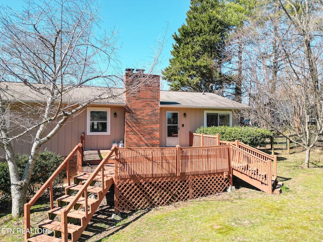 rear view of property with stairway, a yard, a chimney, and a wooden deck