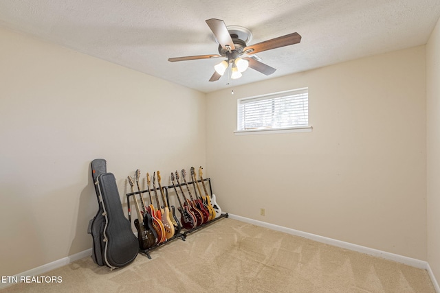 empty room with carpet, a textured ceiling, and baseboards