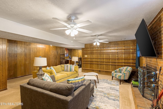 living area with a textured ceiling, carpet floors, a wood stove, and wooden walls