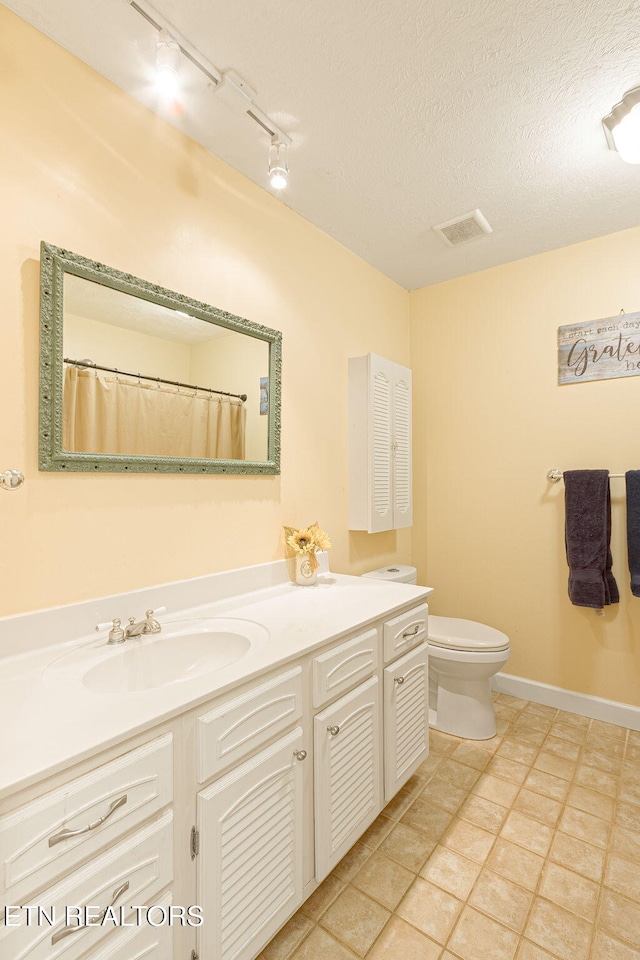 full bathroom featuring a textured ceiling, toilet, visible vents, vanity, and baseboards