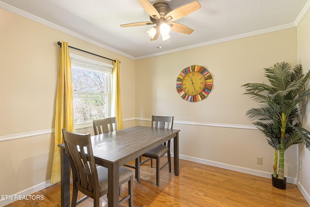 dining space with light wood-style flooring, baseboards, a ceiling fan, and ornamental molding