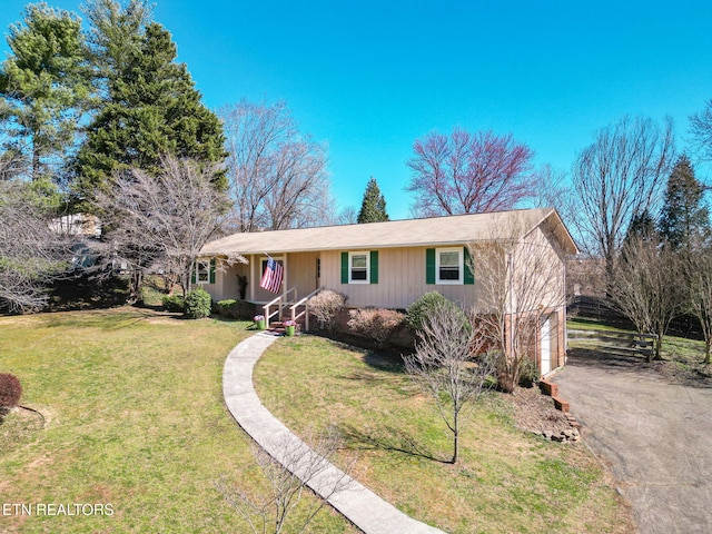 ranch-style house with a garage, aphalt driveway, and a front yard