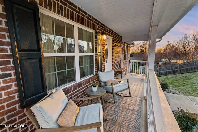 view of patio with a porch and fence